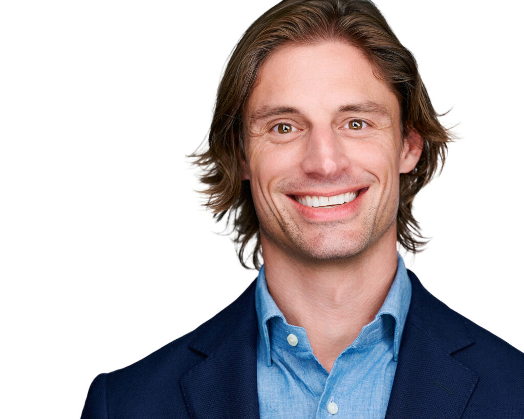 Professional headshot of a smiling businessman wearing a navy blazer and blue button-down shirt against a bright white background in St. Louis, Missouri.