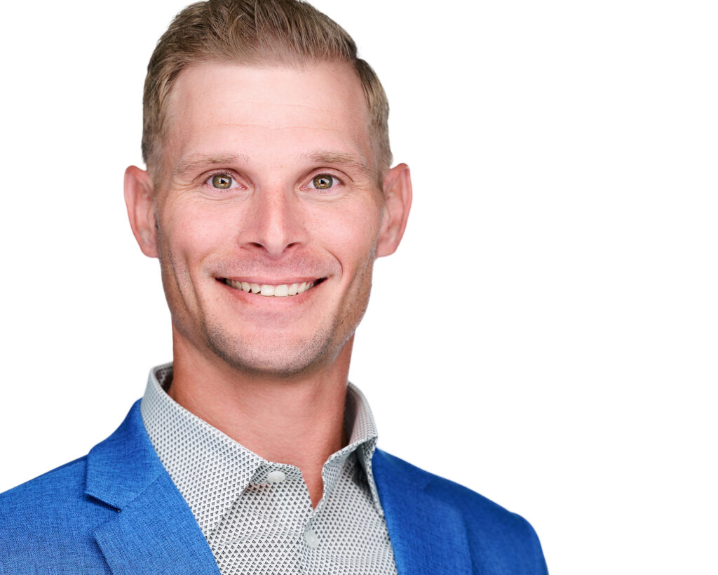 Professional headshot of a smiling businessman wearing a bright blue blazer and patterned dress shirt against a clean white background in St. Louis, Missouri.